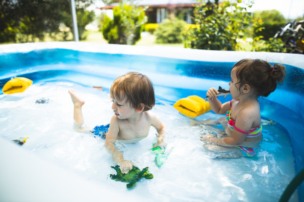 小男孩和小女孩在游泳池里玩图片下载