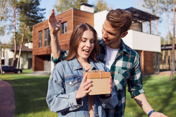 一个惊讶的女人在户外拿着一个装着礼物的盒子图片下载