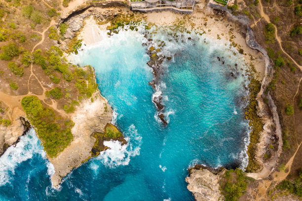 从上到下的鸟瞰图海浪打破了一个小岩石海湾(蓝礁湖，努沙塞宁甘，印度尼西亚)图片下载
