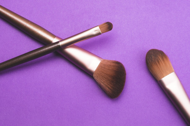 化妆刷在紫色的背景。各种化妆刷。皮肤护理配件图片下载