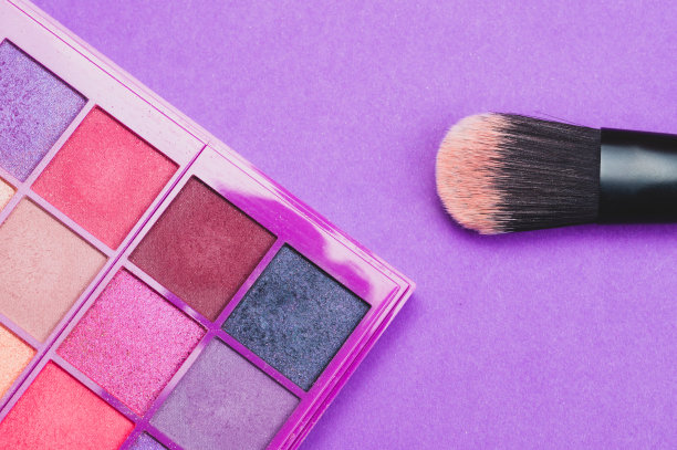 紫色背景上的粉末状化妆刷。各种化妆刷。皮肤护理配件图片下载