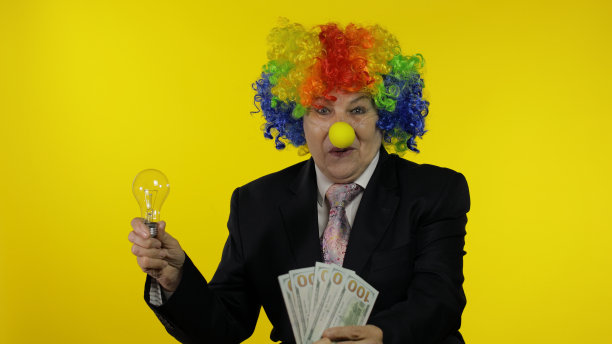 小丑女商人展示灯泡。想出了好主意并收到了钱图片下载