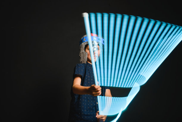 一个手里拿着光剑的孩子在超级英雄的战斗中玩耍。图片下载