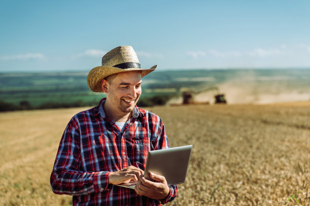 农民用笔记本电脑控制他的田地里的收成图片下载