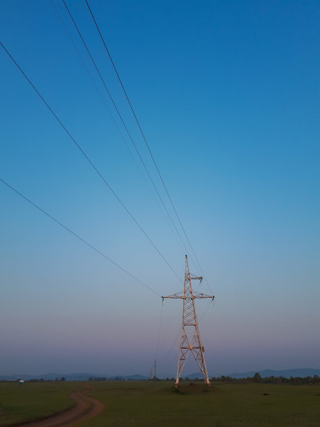 照片中的金属电力线在阳光下呈几何图形，天空是黎明的蓝色图片下载