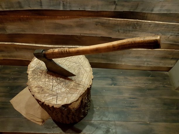 一把斧头在一堵木墙上被钉进一根木棒里图片下载