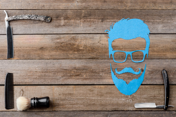 刷子，一个男人的脸轮廓，直剃须刀和梳子在木板上图片下载