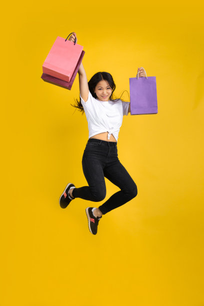 年轻的亚洲女人的肖像孤立在黄色的工作室背景图片下载