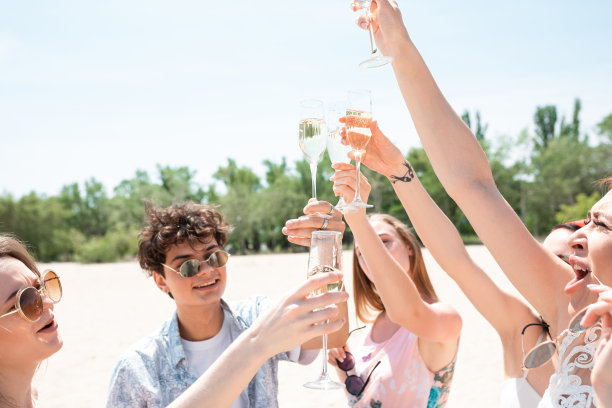海滩度假胜地的季节性盛宴。在阳光明媚的夏日，一群朋友在海滩上庆祝、休息、玩乐图片下载
