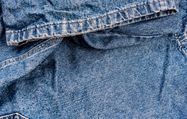蓝色牛仔裤面料。牛仔牛仔裤纹理牛仔牛仔裤的背景。牛仔服装设计。高跟鞋。缝合。照片的背景。图片下载
