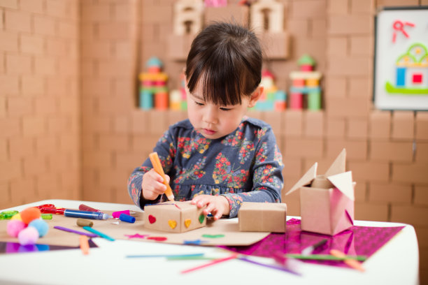 学龄前儿童在家里用纸板块制作工艺品图片下载