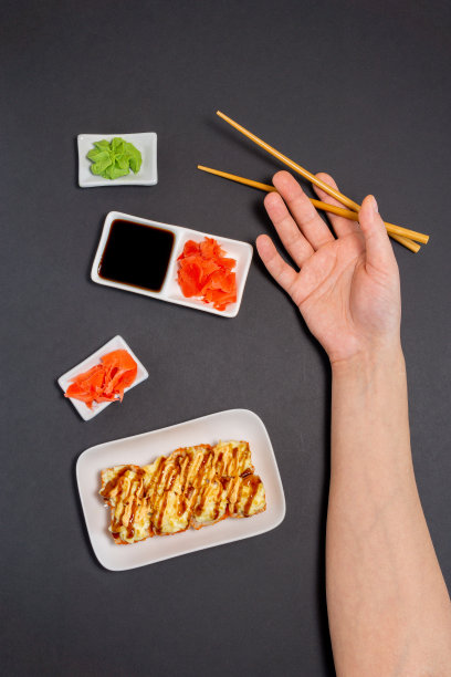 寿司,寿司卷。在盘子上的黑色背景上为你的文本留出空间。垂直照片，俯视图图片下载