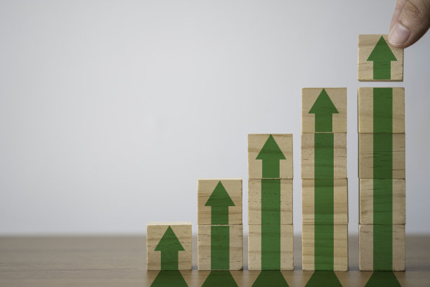 手把打印屏幕上的木方块加大或向上的绿色箭头。它是经济投资利润增长的标志。图片下载