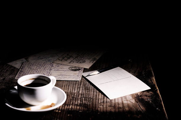木桌上放着旧明信片、咖啡杯和铅笔图片下载