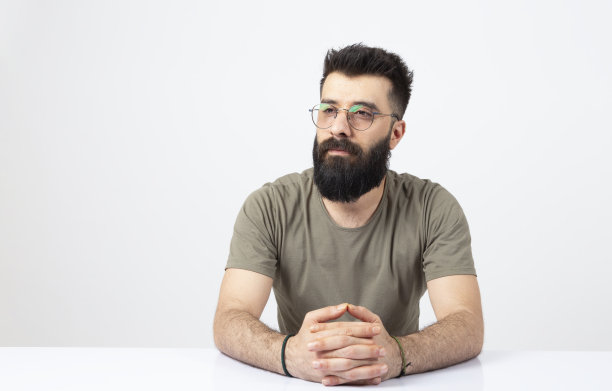 长着胡子的商人坐在桌边。图片下载