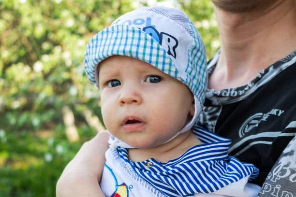 小宝贝在爸爸的怀里看着镜头，有趣的宝贝图片下载