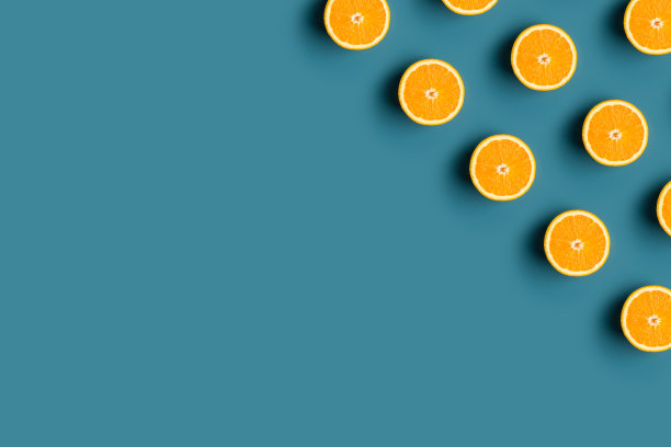 简约的现代图案在角落与成熟的橙色水果在蓝色背景图片下载