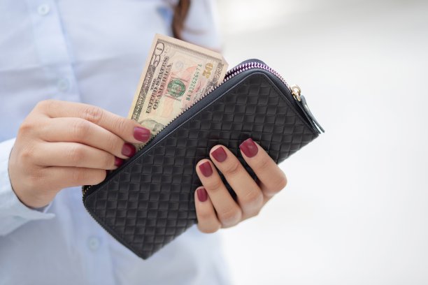 一个女人拿着一个时尚钱包在一家百货公司购物。图片下载