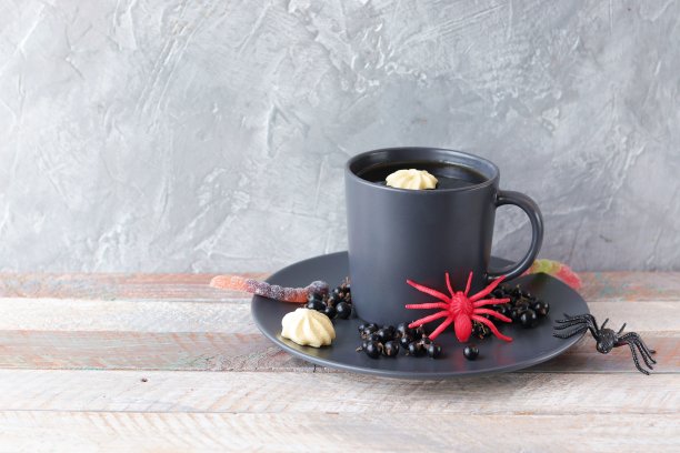 万圣节食物，咖啡和浆果甜点，蛋白酥饼，果冻蠕虫，神秘的装饰图片下载