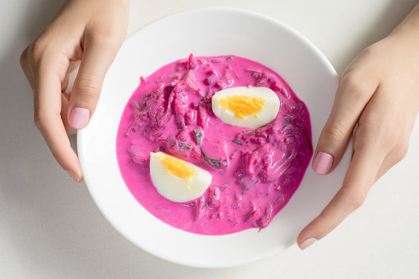 甜菜、鸡蛋和开菲尔酒的冷汤。俄罗斯、波兰、立陶宛的传统美食热天素食照片中女性的手拿着一个盘子。图片下载