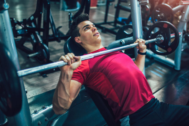 一个男人在健身房做举重训练的照片图片下载