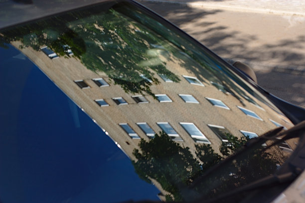 一辆汽车的挡风玻璃反射出一座高楼图片下载