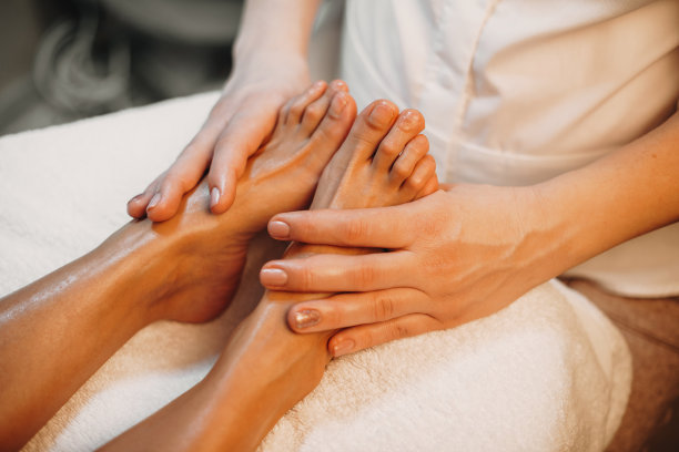 上视图的照片，一个白人按摩师正在水疗沙龙的脚按摩会议图片下载
