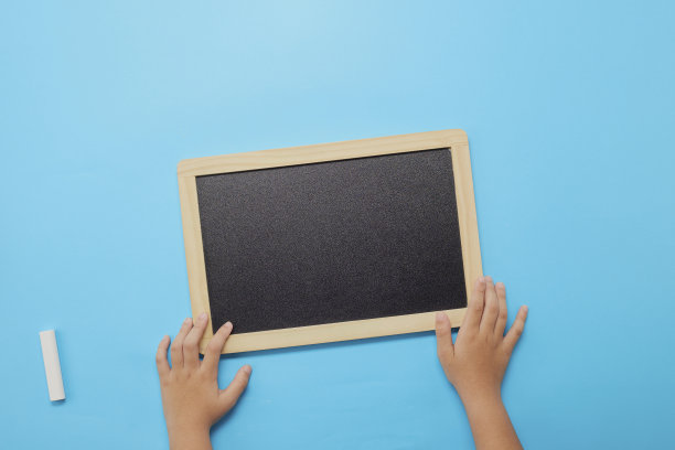 回到学校背景，孩子手中拿着空白的黑板图片下载