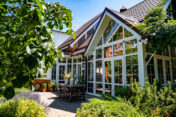 白色的夏日别墅，有全景的窗户。小屋花园中的庭院和餐桌。图片下载