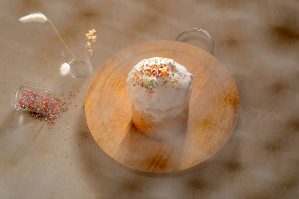 复活节蛋糕。木制的桌子。艺术照片与选择焦点。糖果从玻璃杯里溢出来。干燥的植物。网帘对前景聚焦模糊。复活节和家庭面包房假日概念照片。图片下载