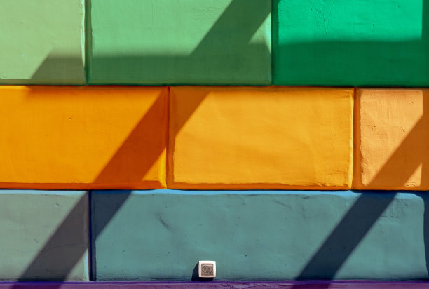 各种颜色的墙壁，电源插座和阴影为背景。抽象的城市和城市空间概念照片。图片下载