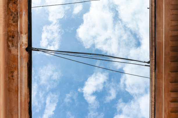 天空，屋顶的古建筑，电缆，小鸽子头剪影从屋顶往下看。底视图照片。图片下载