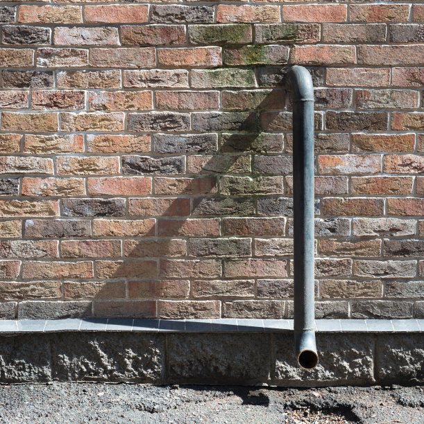 管子和砖墙。纹理复古和垃圾砖墙。城市建筑概念照片。图片下载