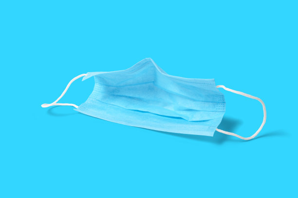 医用口罩蓝色背景。病毒、流感、冠状病毒流行、COVID - 19大流行、细菌、感染和肺炎保护概念照片。图片下载