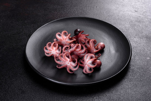 黑色盘子里的小章鱼沙拉图片下载