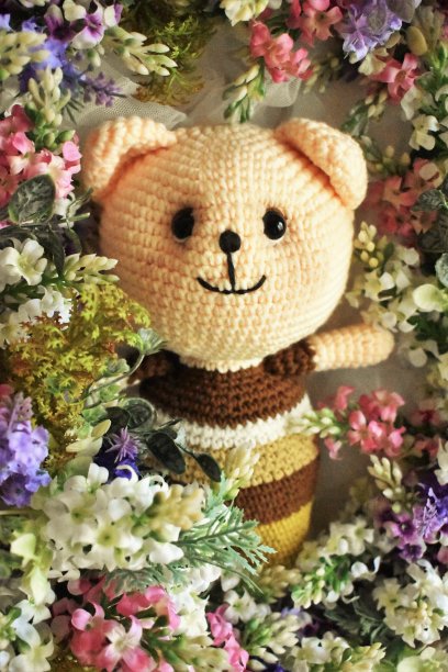 熊钩针。复古的主题。羊毛。绿色的火焰。森林的主题。针织的背景。柔和的古董。家居装饰。毛的动物。手工制作的。叶子。儿童动物玩具。棕色的熊。可爱的钩编图片下载