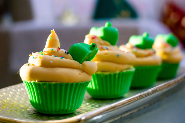 美丽的纸杯蛋糕肥皂，紫色和绿色的糖霜，粉红色和黑巧克力的基础上，糖果撒在一个木制的背景图片下载