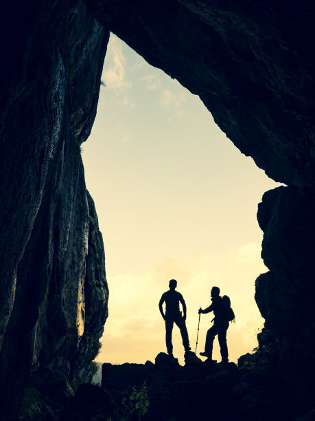 洞穴探险的两个无畏和勇敢的冒险家和远足在神秘的地方在不寻常的山图片下载