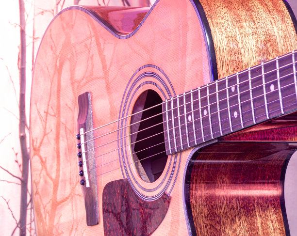 原声吉他在美丽的彩色背景。弦乐器的概念。图片下载