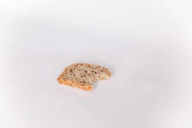 一片被咬过的面包，白色的背景上有谷物图片下载