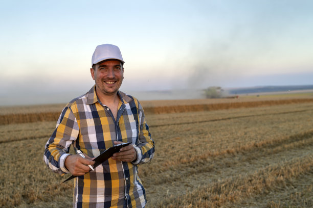 农业:在麦田里使用计算机的农民或牧场主图片下载