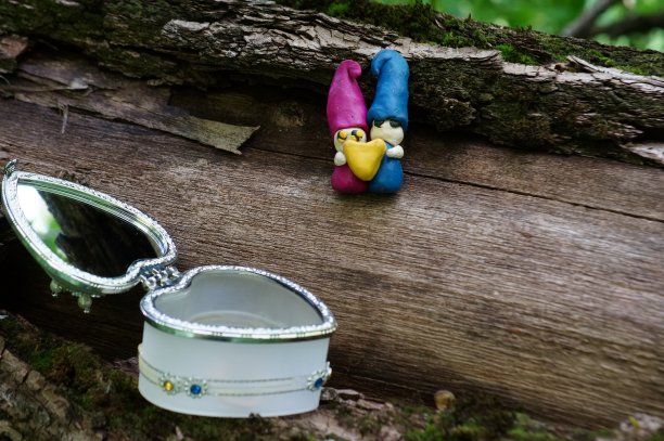 两个相爱的小矮人捧着一颗心。图片下载