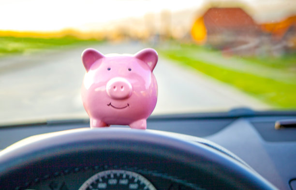 存钱罐坐在汽车的仪表盘上图片下载