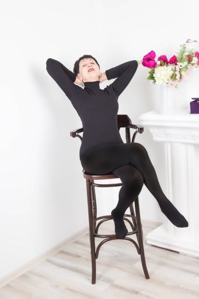 资深女性坐在家里的现代椅子上放松图片下载