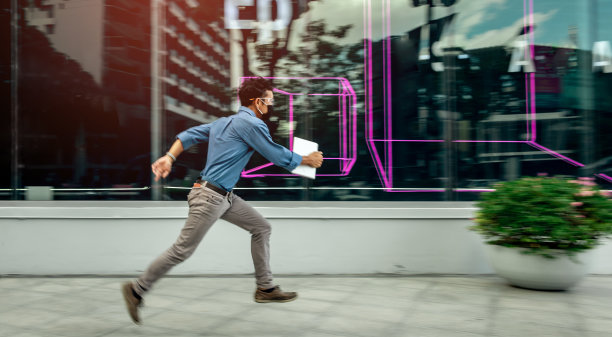 男人匆忙地跑过橱窗里的紫色霓虹灯。图片下载