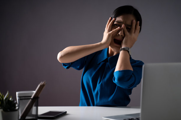 在办公室里，穿蓝色衬衫的亚洲女人吓坏了，尖叫着。背景隔离。图片下载