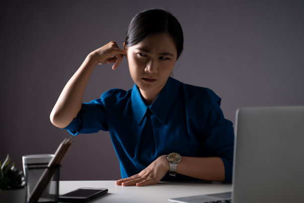 亚洲妇女在蓝色衬衫瘙痒和把一个手指放进她的耳朵在办公室。孤立在白色背景上。图片下载