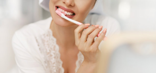 一个女人正在刷牙。早上的口腔卫生。特写与复制空间。有魅力的女孩，早上淋浴后头戴浴巾图片下载
