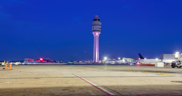 空中交通管制塔后与加油卡车在一个柔和的蓝色夜空。图片下载