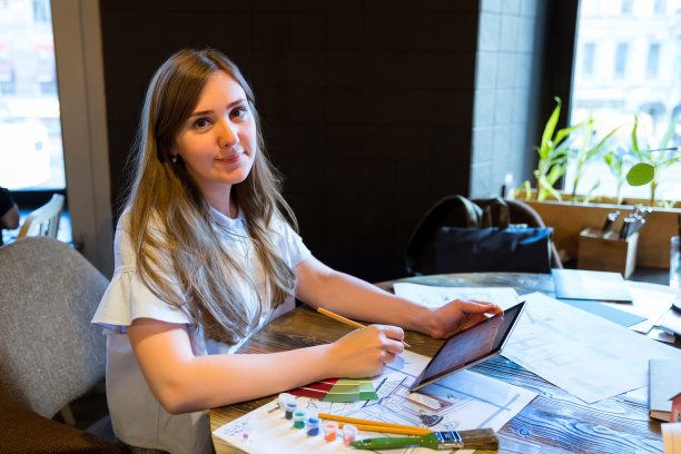 女孩正在用平板电脑和艺术家工具进行室内项目图片下载